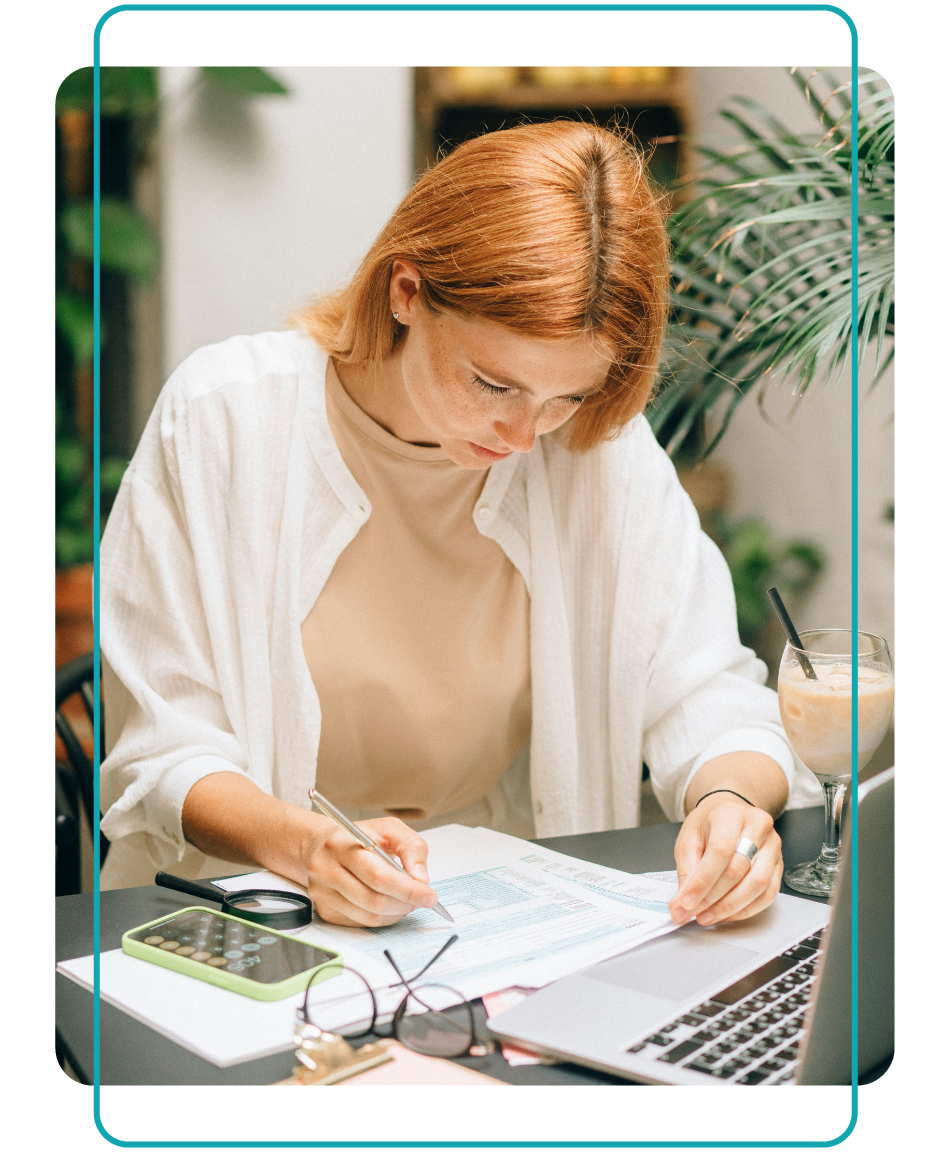 Woman working on budgeting with her paperwork, calculator and laptop