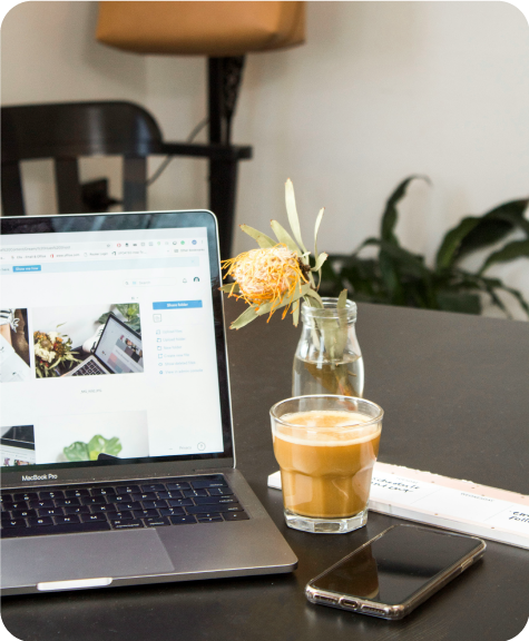 BRI_Resizingforblogs-33 A laptop and latte sit on a table with a mobile phone to the side.