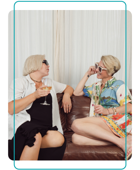 BRI_Resizingforblogs-35 Leah and Jus wearing sunglasses, sit on a couch laughing and drinking champagne